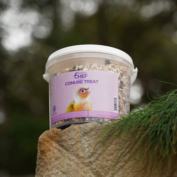 Container of Feather Chef Conure Treats  with a bird on a natural background