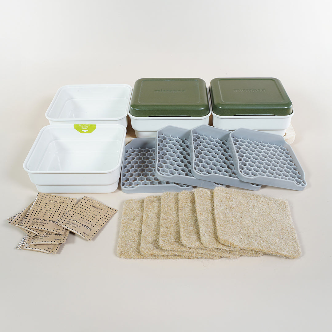Micropod Continuous Grow Kit unpacked to show all inclusions, including trays, wooden base, and seed mats for staggered microgreens harvests with Seed Cube feeding.